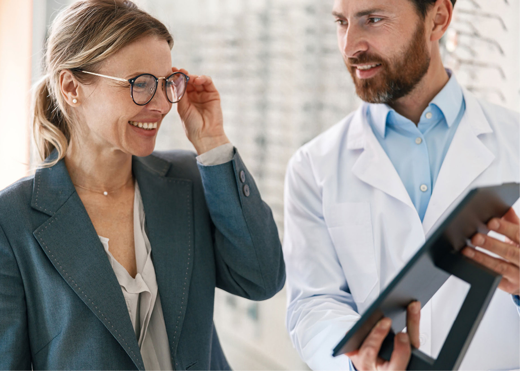 Zwei Personen in einem Gesch ft f r Brillen probieren eine Brille aus und betrachten gemeinsam ein Tablet. Beschreibung von KI generiert